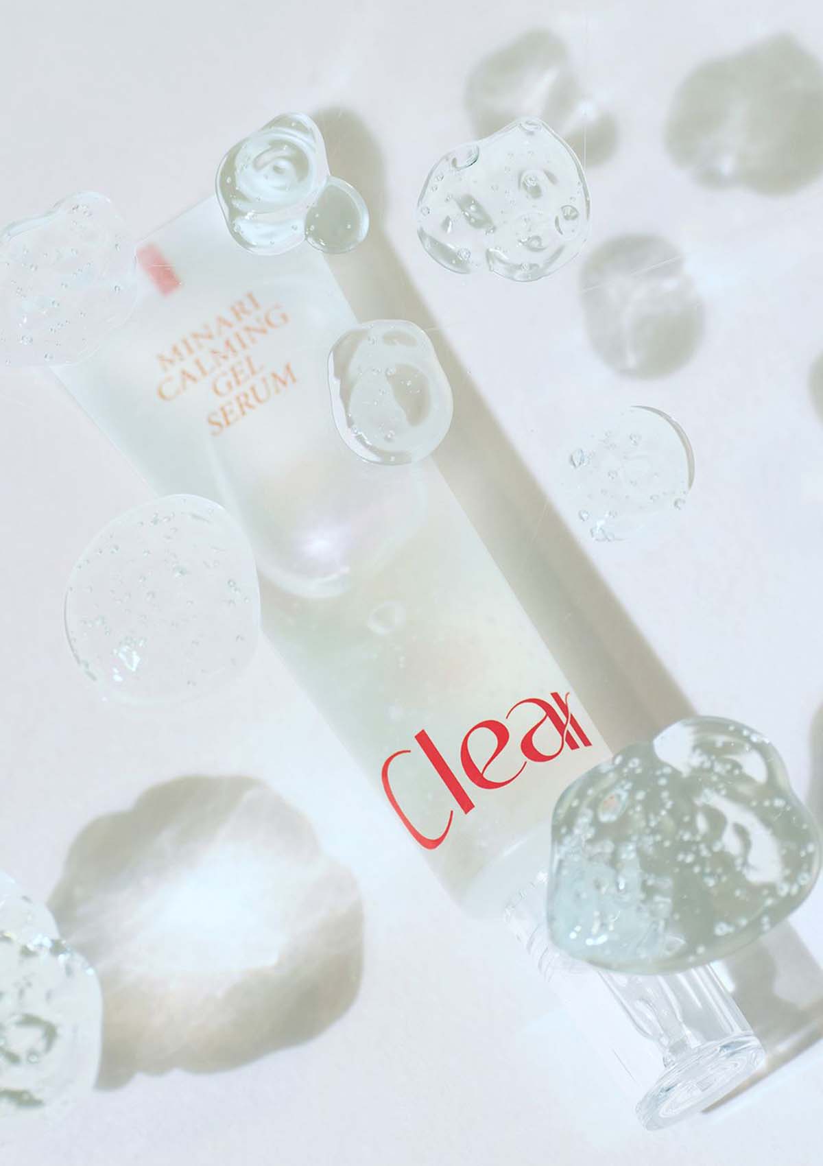 Skincare serum bottle with droplets on a light background